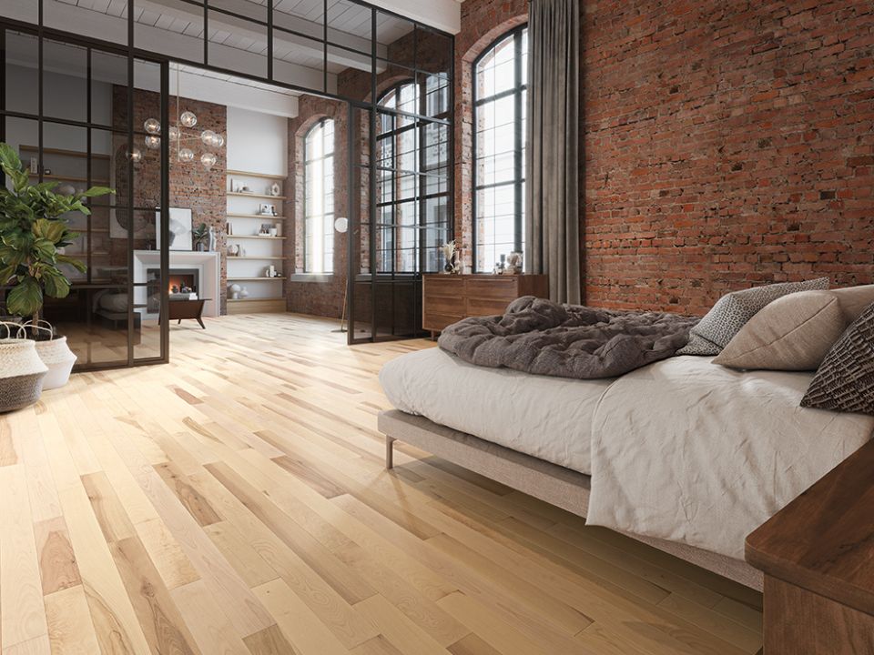 Chambre chaleureuse avec des plancher de bois, des coussins volumineux et des grandes fenêtres