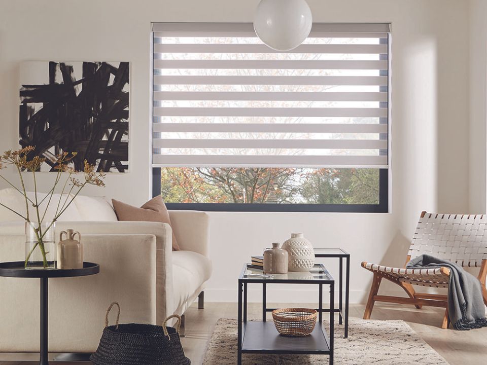 Salon lumineux avec stores alternés blancs et chaise tissée